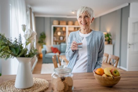 Photo for Close up portrait of one senior woman with short hair happy smile positive emotion copy space standing at home indoor gray white hair hold glass of water - Royalty Free Image