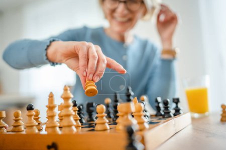 Photo for Two senior mature women caucasian female woman friends or sisters play leisure chess board game at home have fun spend time together at home bright photo copy space - Royalty Free Image