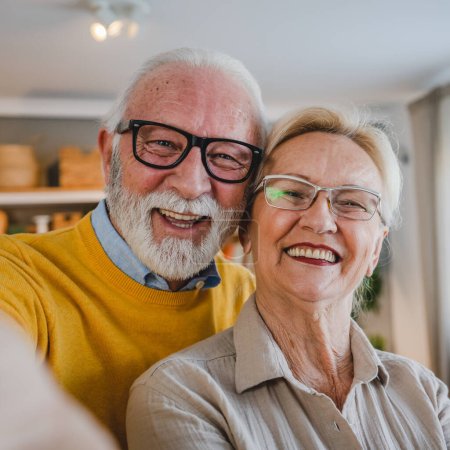 Foto de Retrato de marido y mujer mayores feliz caucásico hombre y mujer pareja de edad en casa tomando autorretrato selfie - Imagen libre de derechos