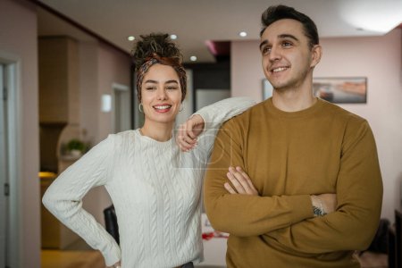 Téléchargez les photos : Happy couple woman and man caucasian husband and wife or girlfriend and boyfriend standing at home happy smile in their apartment real people copy space - en image libre de droit