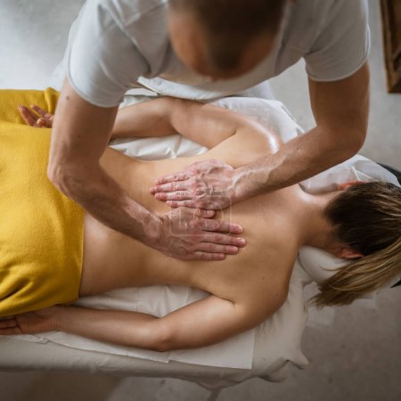 Photo for Unknown woman lying while have back massage by male caucasian therapist at beauty spa treatments salon healthcare relaxation concept copy space top view - Royalty Free Image