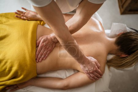 Photo for Unknown woman lying while have back massage by male caucasian therapist at beauty spa treatments salon healthcare relaxation concept copy space - Royalty Free Image