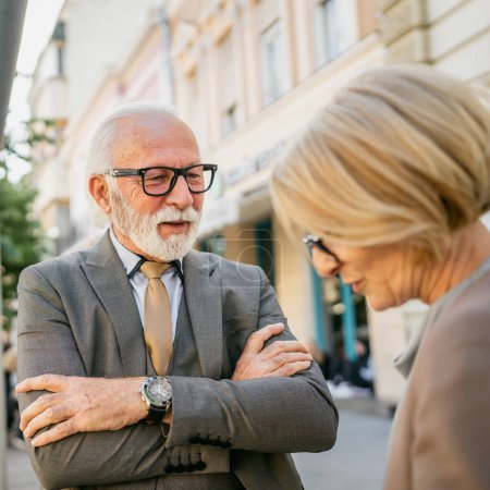 Photo for Couple old friends or family senior man and mature caucasian woman stand in the city in day talk long time no see family or business partners real people copy space wear formal suit - Royalty Free Image