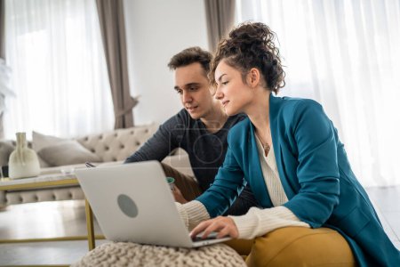 Photo for Couple man and woman young adult caucasian sitting on the floor at home with laptop computer working with husband family concept happy smile freelance brunette domestic life copy space - Royalty Free Image