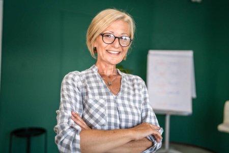Foto de Retrato de una mujer caucásica rubia madura con gafas en casa u oficina sonrisa feliz mirando a la cámara con confianza copia espacio - Imagen libre de derechos