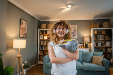 Photo for Portrait of caucasian adult woman with curly hair stand at home hold kettlebell girya wear white t-shirt before or after training healthy lifestyle concept copy space - Royalty Free Image