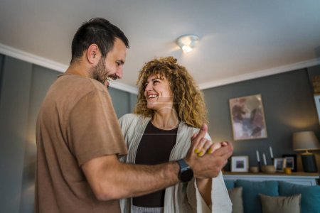 Téléchargez les photos : Heureux couple adulte caucasien homme et femme mari et femme danse à la maison - en image libre de droit