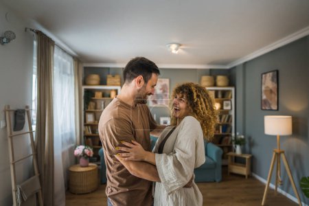 Photo for Happy couple adult caucasian man and woman husband and wife dance at home - Royalty Free Image