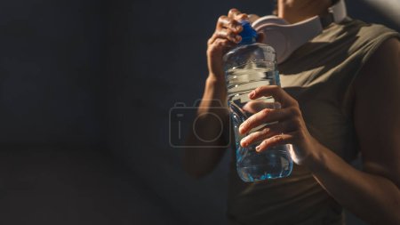 Foto de Primer plano en las manos sección media de mujer caucásica desconocida abierta botella de plástico de agua, mientras que de pie al aire libre en el día soleado - Imagen libre de derechos