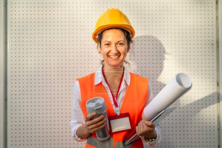 Photo for Architect woman female construction engineer stand outdoors wear protective helmet and west in front of modern building wall - Royalty Free Image
