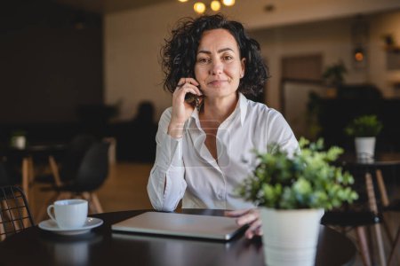 Photo for Female manager or entrepreneur at work use mobile phone smartphone wear white shirt while taking a brake from work businesswoman communication concept real person copy space make a call talking - Royalty Free Image