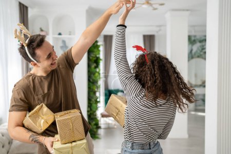 Photo for Woman young adult caucasian female standing at home with gift box presents holding in hands while her boyfriend or husband man give boxes happy smile real people celebrate surprise love dance - Royalty Free Image