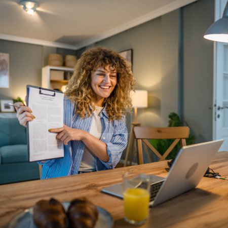 Téléchargez les photos : Une femme adulte travail caucasien sur son ordinateur portable à la maison sourire heureux - en image libre de droit