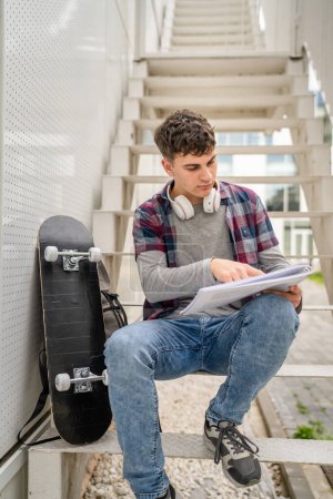 Photo for One Young man teenager caucasian student with books read study at campus in day sit on staircase education concept copy space - Royalty Free Image