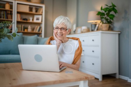 Foto de Senior mujer caucásica utilizar ordenador portátil en casa para el trabajo - Imagen libre de derechos