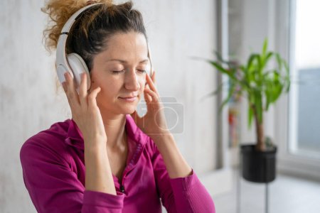 Photo for One woman adult caucasian female millennial using headphones for online guided meditation practicing mindfulness yoga with eyes closed on the floor at home real people copy space self-care concept - Royalty Free Image