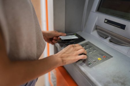 Foto de Manos de la mujer que utiliza la tarjeta de crédito y retirar dinero en efectivo en el cajero automático - Imagen libre de derechos