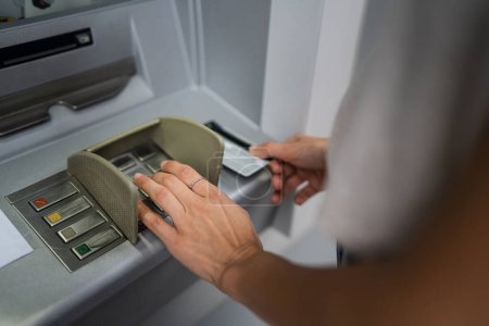 Foto de Manos de la mujer que utiliza la tarjeta de crédito y retirar dinero en efectivo en el cajero automático - Imagen libre de derechos