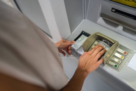 Téléchargez les photos : Mains de la femme utilisant la carte de crédit et retirer de l'argent au guichet automatique - en image libre de droit