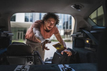 Photo for One adult man travel concept male take stuff belongings from the back or put in trunk of the car while moving to travel or arrive to destination real people copy space - Royalty Free Image