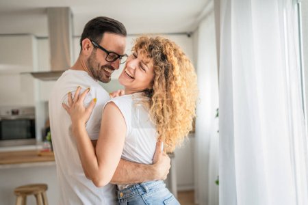 Photo for Happy caucasian adult couple man and woman at home together smile husband and wife or boyfriend and girlfriend stand have fun - Royalty Free Image