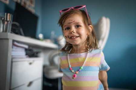 Foto de Niña caucásica niño con dibujos de color pintado y manchas en la cara - Imagen libre de derechos