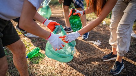 Photo for Hands of group of friends gen Z male and female caucasian picking up waste garbage plastic bottles and paper from the forest cleaning up nature in sunny day environmental care ecology concept - Royalty Free Image