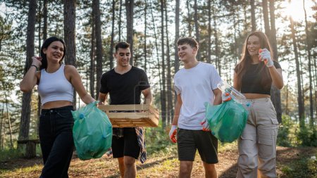 Photo for Group of teenage friends gen Z male and female caucasian men women picking up waste garbage plastic bottles and paper from the forest cleaning up nature in sunny day environmental care ecology concept - Royalty Free Image