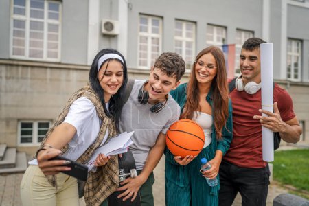 Téléchargez les photos : Groupe d'adolescents prennent selfie autoportrait en face de l'école université hommes et femmes amis caucasien homme femme adolescentes en face du campus attendre le concept de la classe de retour à l'école - en image libre de droit