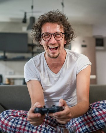Photo for Adult man caucasian male play console video games at home hold joystick controller have fun leisure joy and win and success concept copy space - Royalty Free Image