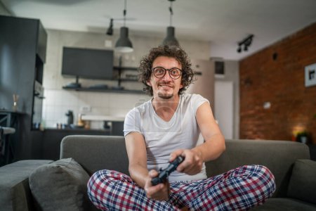 Photo for Adult man caucasian male play console video games at home hold joystick controller have fun leisure joy and win and success concept copy space - Royalty Free Image