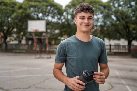 Téléchargez les photos : Un jeune homme caucasien adolescent tenir supplément shaker stand extérieur - en image libre de droit