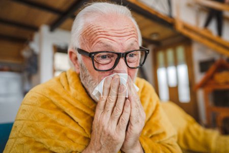 Photo for One caucasian male senior man sit on sofa bed at home hold Paper tissue common cold sneezing - Royalty Free Image