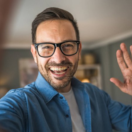 Foto de Un hombre adulto retrato de caucásico macho con barba y gafas de pie en casa feliz sonrisa copia espacio autorretrato selfie - Imagen libre de derechos