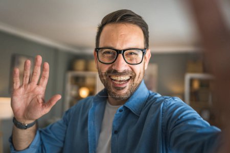 Foto de Un hombre adulto retrato de caucásico macho con barba y gafas de pie en casa feliz sonrisa copia espacio autorretrato selfie - Imagen libre de derechos