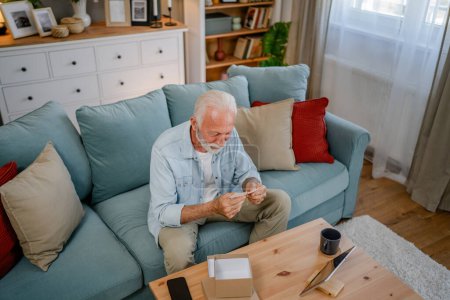 Photo for One senior man grandfather pensioner with gray hair and beard receive presents in box open read card happy smile in front of laptop computer at home having online video call copy space - Royalty Free Image