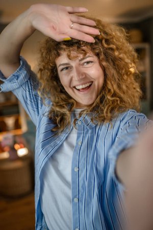 Foto de Retrato de una mujer caucásica adulta en casa sonrisa feliz pelo rizado - Imagen libre de derechos