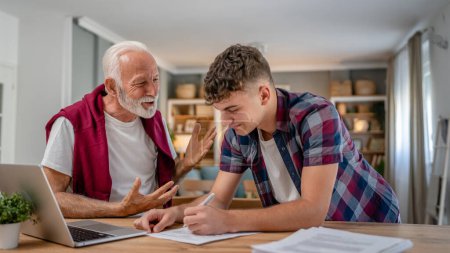 Photo for One student teenage caucasian man teen study learn with help of his tutor professor or grandfather senior man at home having private lesson to prepare for exam education concept real people copy space - Royalty Free Image