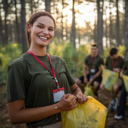Photo for Portrait of caucasian female teenager activist volunteer during picking up waste garbage plastic bottles paper from forest cleaning up nature in sunny day environmental care ecology campaign concept - Royalty Free Image