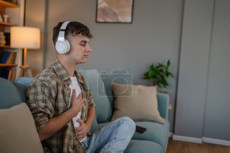 Photo for One teenager man young caucasian male use headphones for online guided meditation practice mindfulness yoga with eyes closed at home real people self care manifestation concept copy space generation Z - Royalty Free Image