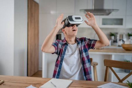 Téléchargez les photos : Garçon caucasien adolescent jeune homme étudiant profiter réalité virtuelle VR casque à la maison tout en prenant un frein - en image libre de droit