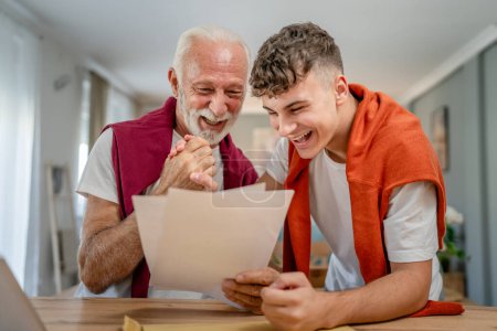 Photo for Senior man grandfather and caucasian man teenager boy grandson receive letter read good news student get scholarship or invitational letter from university share excitement real people - Royalty Free Image