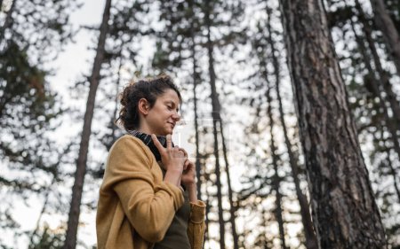 Foto de Una mujer joven adulta caucásica sola en el parque o bosque en la naturaleza con auriculares que se preparan para la meditación guiada auto-cuidado manifestación práctica mental equilibrio emocional concepto - Imagen libre de derechos