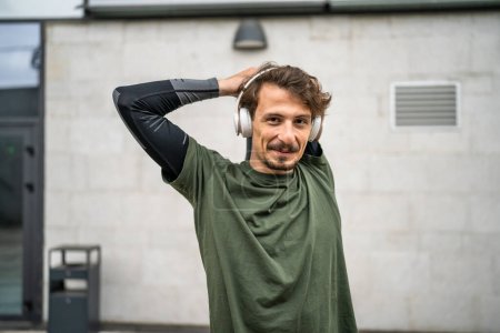 Téléchargez les photos : One man modern caucasian male stretch outdoor before training wear green shirt and mustaches and beard young adult recreational activity - en image libre de droit