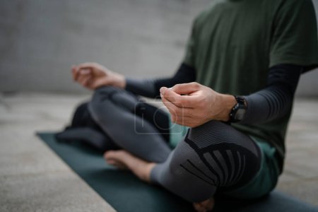 un hombre haciendo meditación guiada en línea yoga autocuidado concepto al aire libre de cerca en las manos de sección media