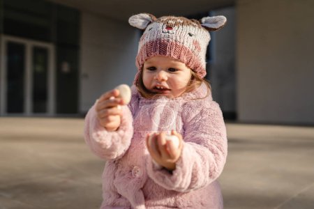 Téléchargez les photos : Petite fille caucasienne tout-petit jouer en face de la construction dans la journée d'hiver - en image libre de droit
