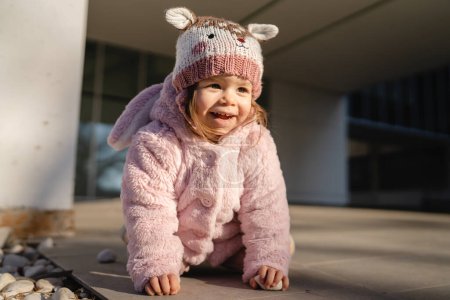 Téléchargez les photos : Small caucasian girl toddler play in front of building in winter day - en image libre de droit