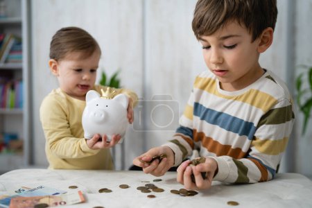 Photo for Siblings boy and girl small caucasian child brother and sister play at home with piggy bank saving money childhood investment insurance and finance concept copy space - Royalty Free Image
