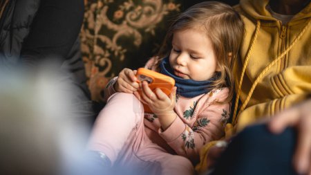 Téléchargez les photos : One girl small caucasian toddler child use mobile smart phone - en image libre de droit