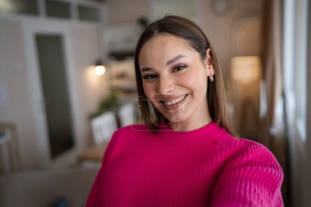 Vorderseite Porträt einer kaukasischen Frau junge Frau stehen in ihrer Wohnung zu Hause tragen Pullover glücklich zuversichtlich echte Menschen kopieren Raum UGC Selfie Benutzer generierte Inhalte glückliches Lächeln